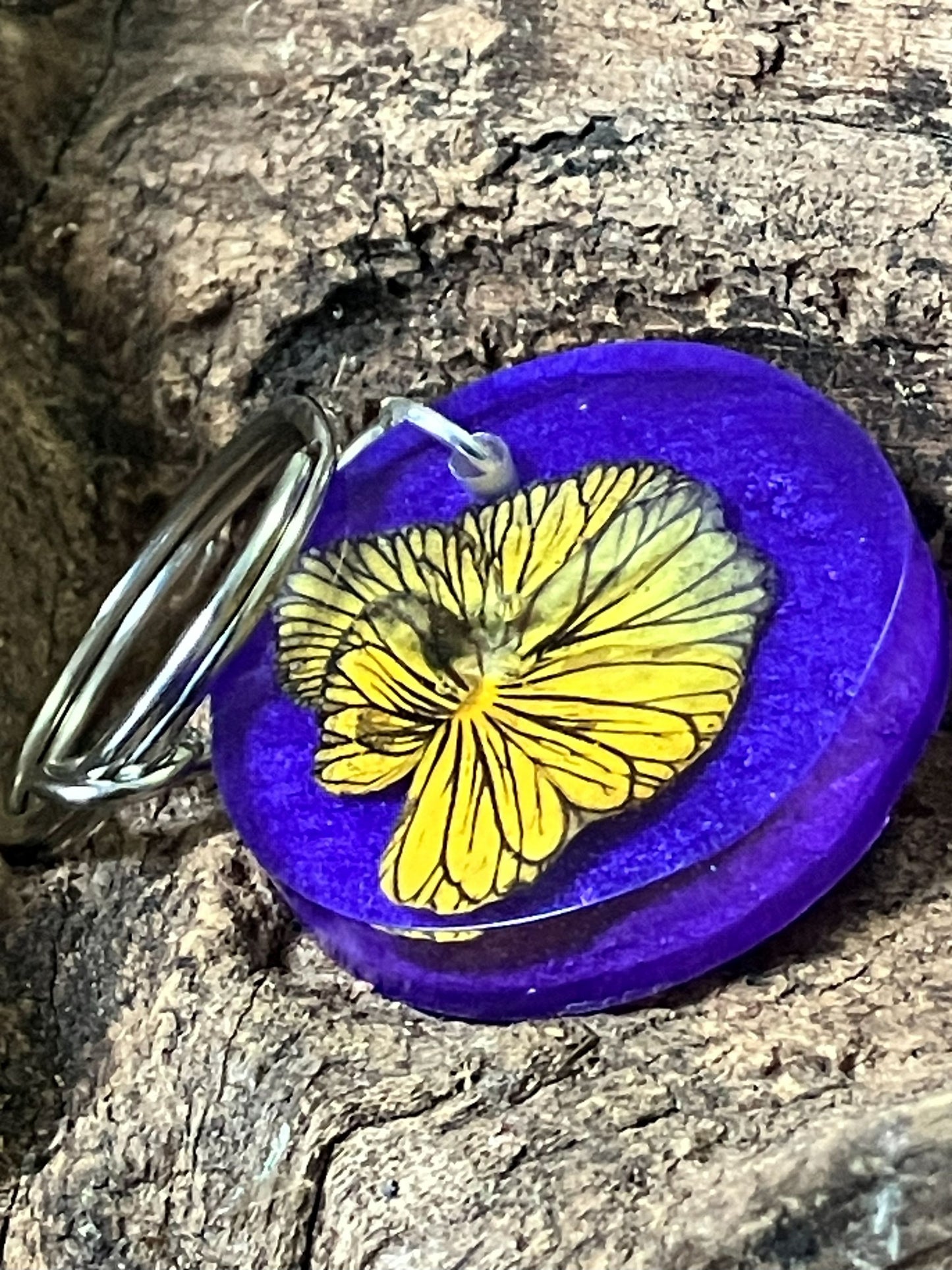 Resin keychain with real Tiger Eye pansy on a blue and purple background, handcrafted by R & D Floral.