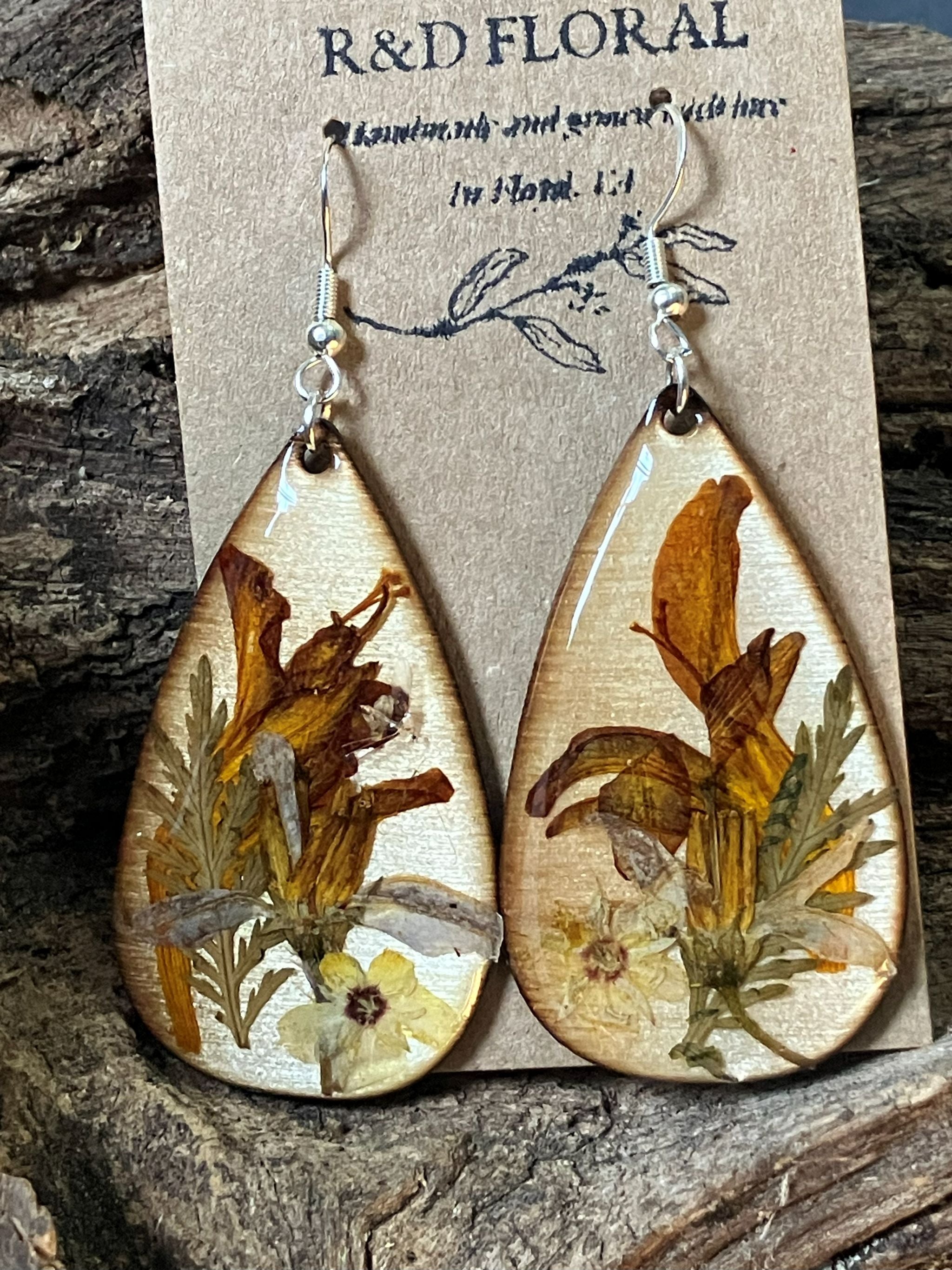 Handcrafted wooden earrings featuring real crocosmia and hypericum flowers in vibrant summer tones encased in resin by R & D Floral.