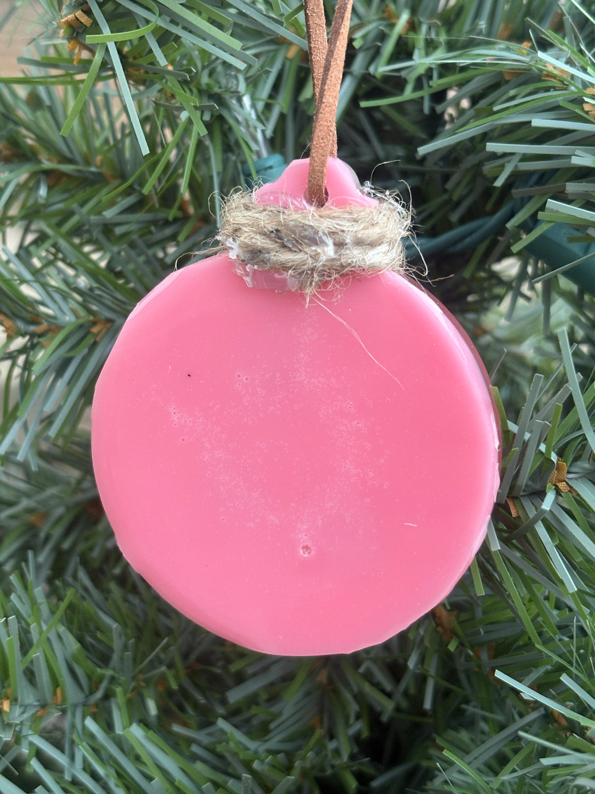 Back of the daisy pink resin ornament showing the smooth reverse side
