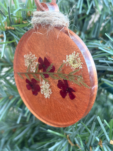 Close-up of Verbena and Queen Anne's Lace pressed flower ornament in copper resin