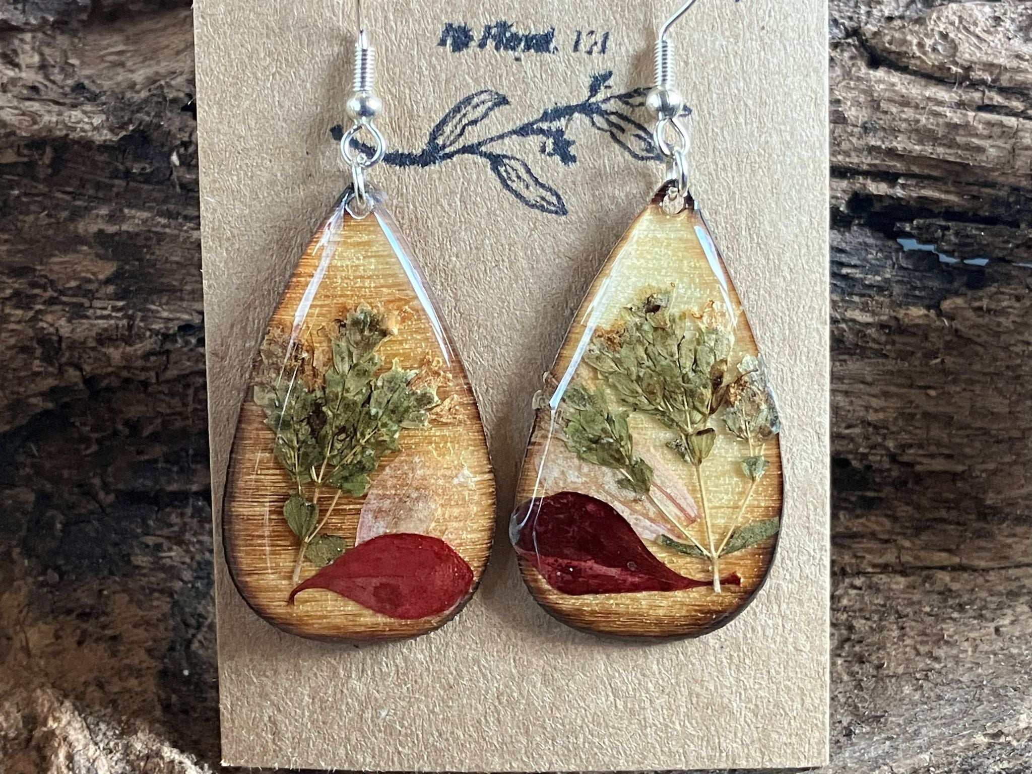 Handmade wooden earrings featuring real oregano, zinnia, and barberry encased in resin by R & D Floral.