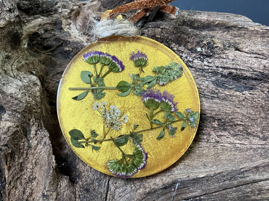 Resin flower ornament with real ageratum and thyme flowers on a leather cord hanger by R & D Floral.