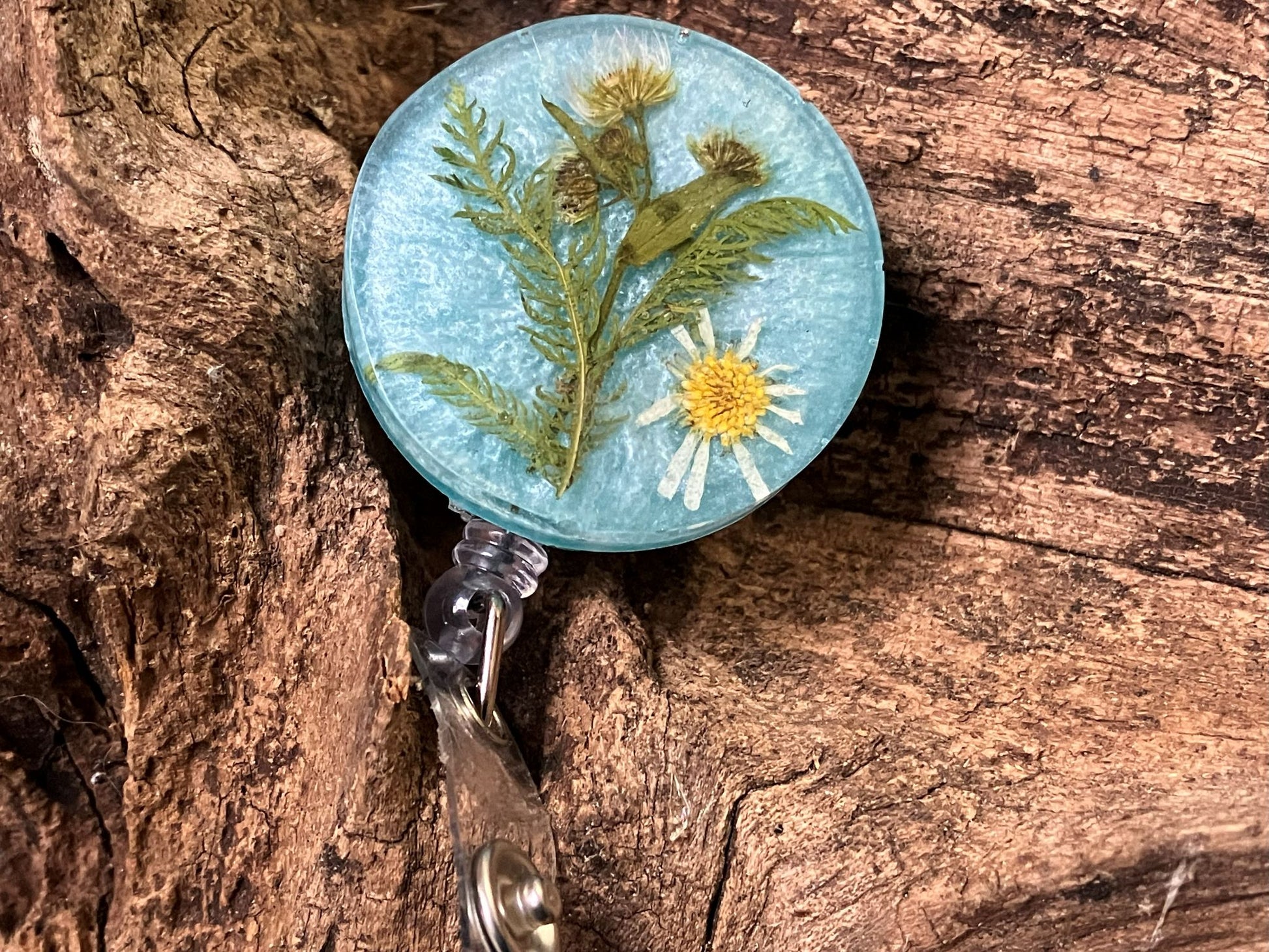 Handcrafted resin badge reel featuring real pressed daisies encased in clear resin by R & D Floral.