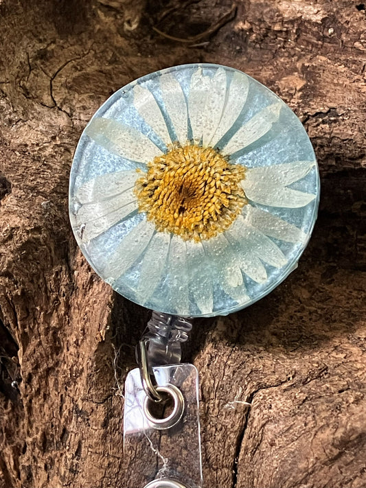 Shimmery blue resin badge reel with real pressed daisies, handcrafted by R & D Floral.