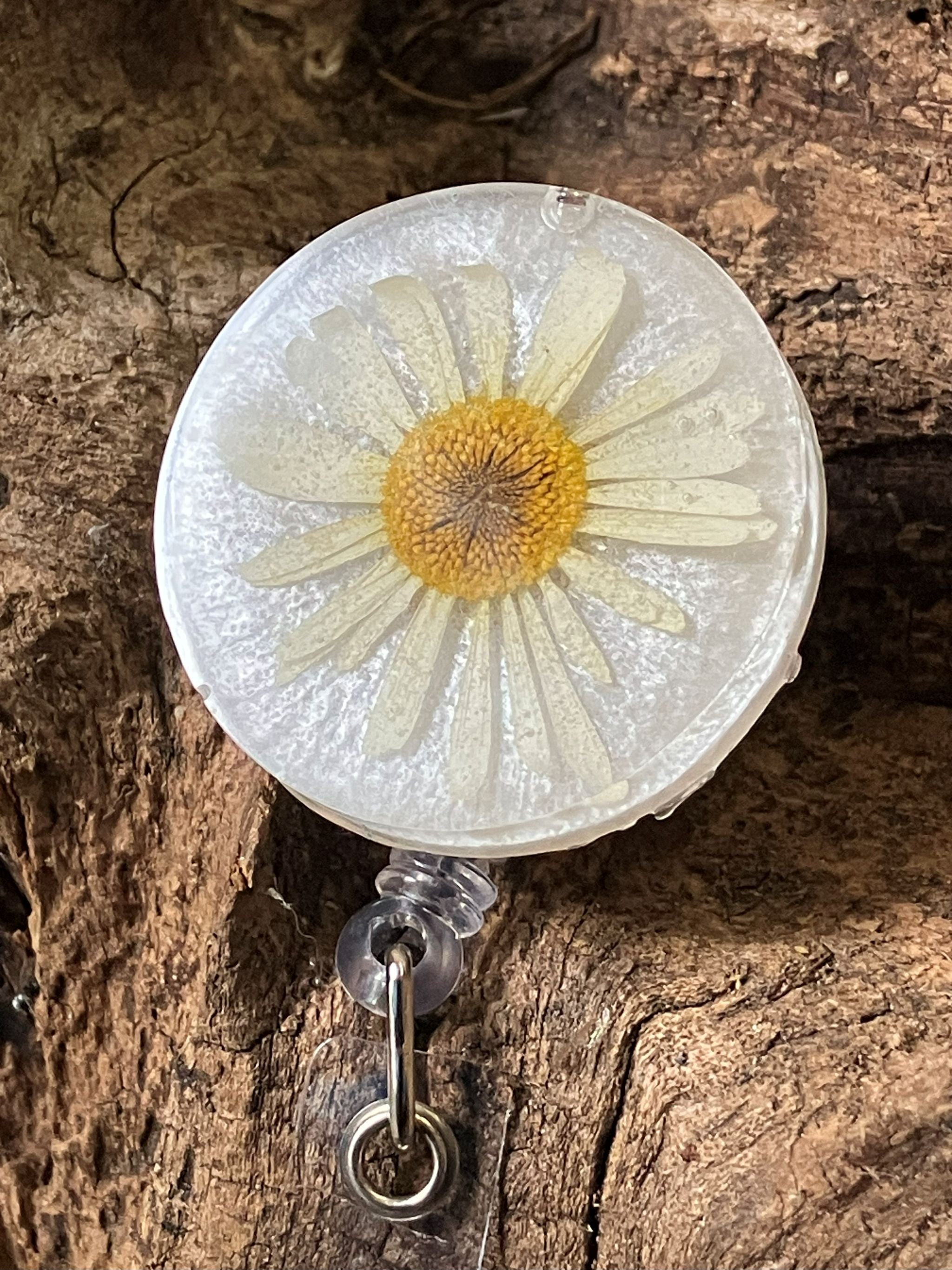 Shimmery white resin badge reel with real pressed daisies, handcrafted by R & D Floral.