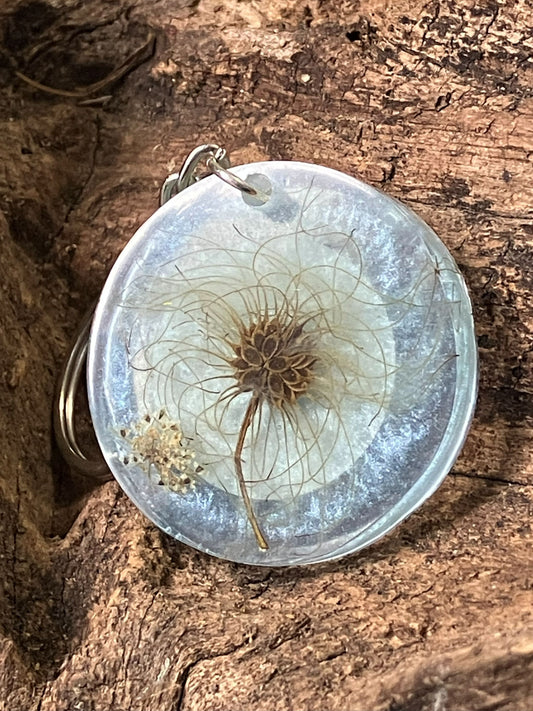 Clear resin keychain with real dandelion seeds preserved inside, handcrafted by R & D Floral.