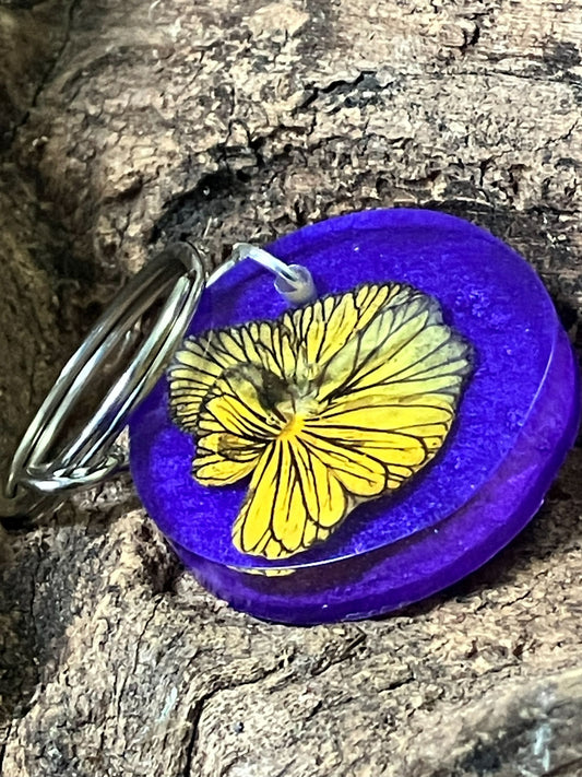 Resin keychain with real Tiger Eye pansy on a blue and purple background, handcrafted by R & D Floral.