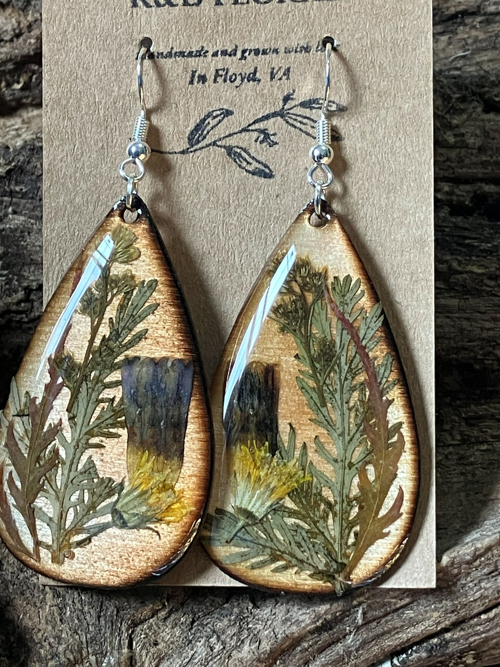Handcrafted wooden earrings with real moonflower petals in smoky, earthy tones encased in resin by R & D Floral.