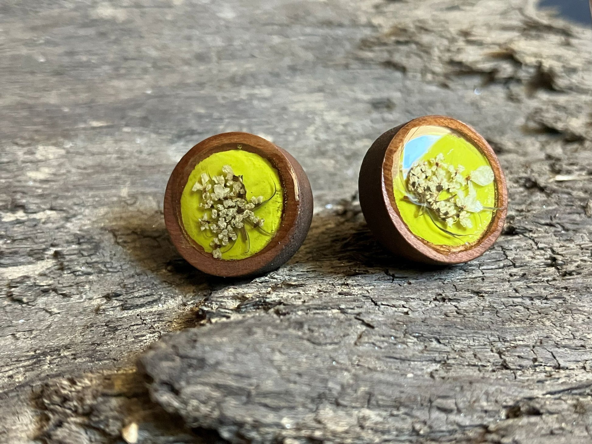 Hand-painted yellow wooden stud earrings with Queen Anne’s lace encased in resin, handcrafted by R & D Floral.