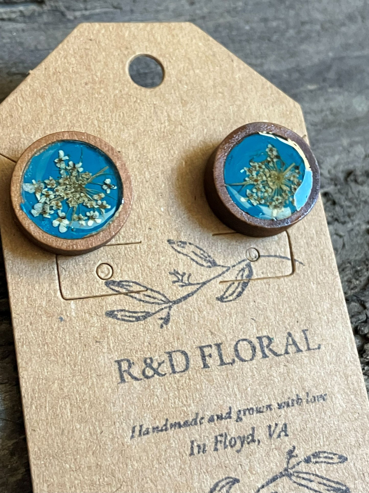 Hand-painted teal wooden stud earrings with real Queen Anne’s lace preserved in resin by R & D Floral.