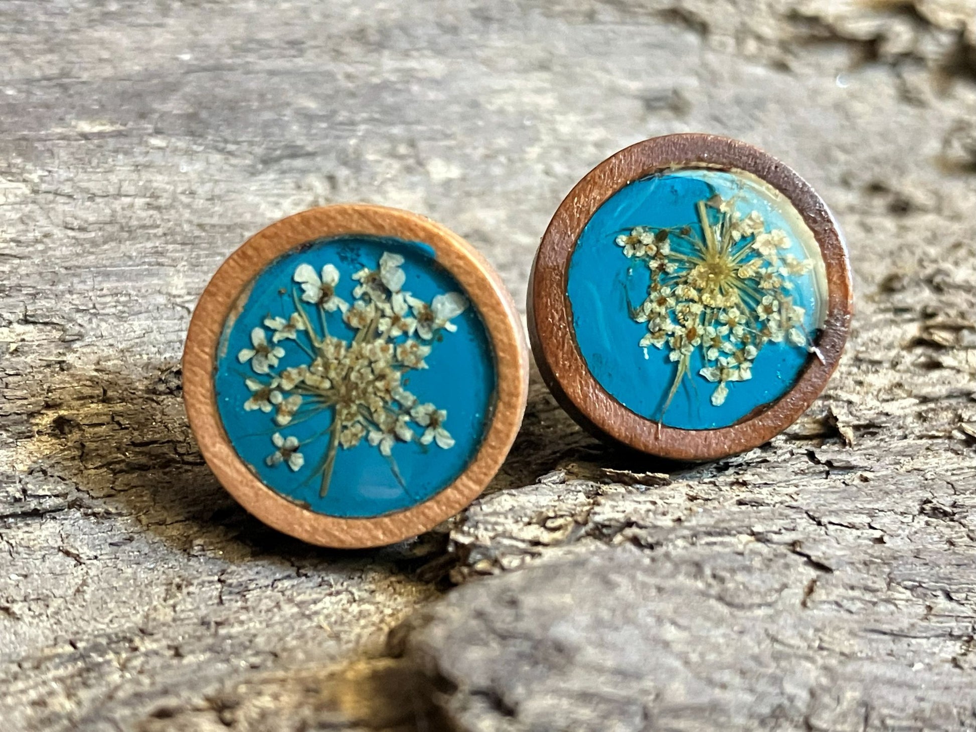 Hand-painted teal wooden stud earrings with real Queen Anne’s lace preserved in resin by R & D Floral.