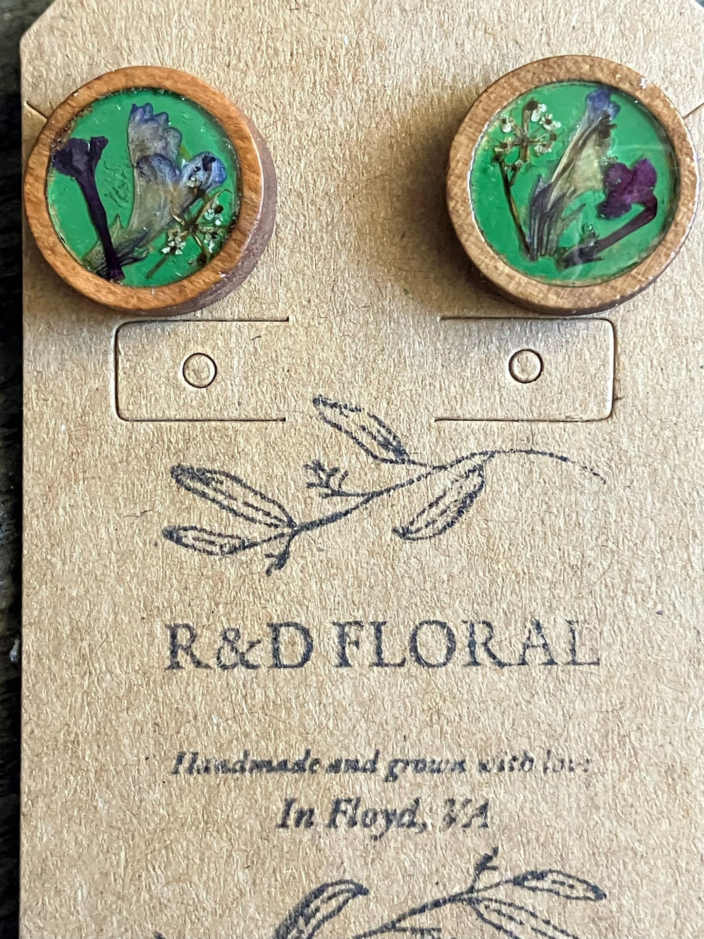 Hand-painted green wooden stud earrings with multiple pressed flowers preserved in resin by R & D Floral.
