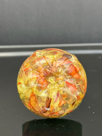 Drawer knob featuring real marigold petals and seeds preserved in clear resin over a contrasting green background.