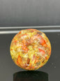 Drawer knob featuring real marigold petals and seeds preserved in clear resin over a contrasting green background.