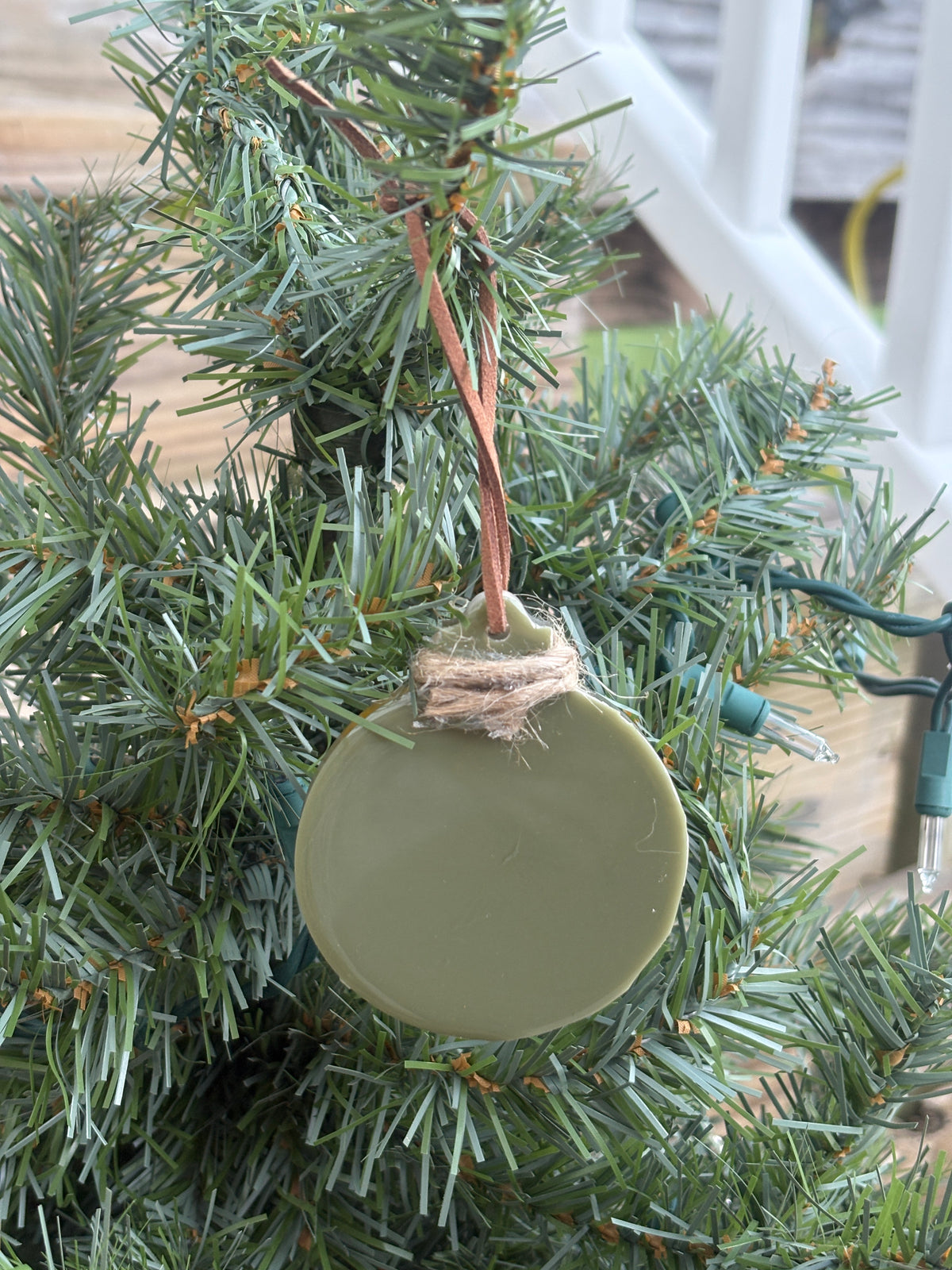 Back of the buttercup and verbena sage green resin ornament showing the smooth reverse side