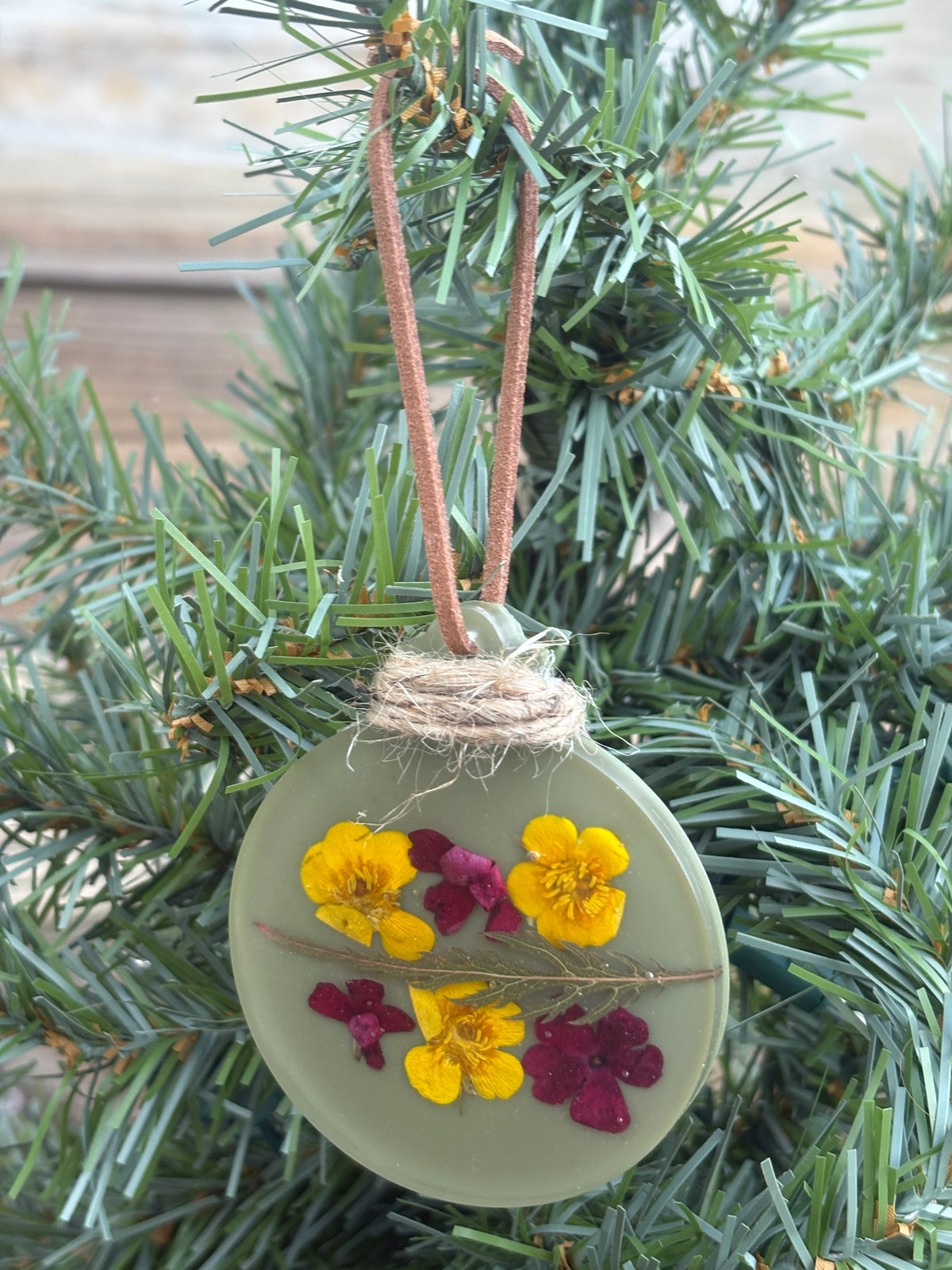 Buttercup and verbena pressed flower ornament in sage green resin on leather cord