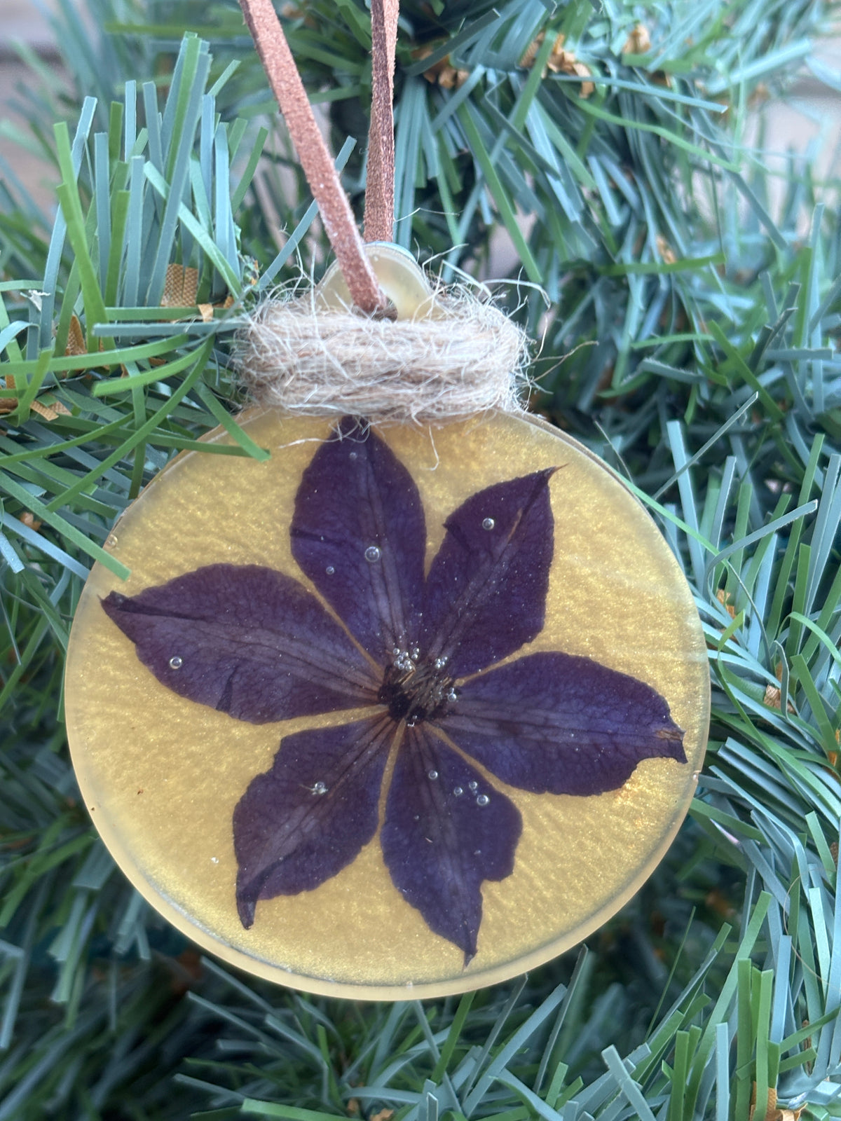 Pressed clematis flower ornament in gold resin on jute twine