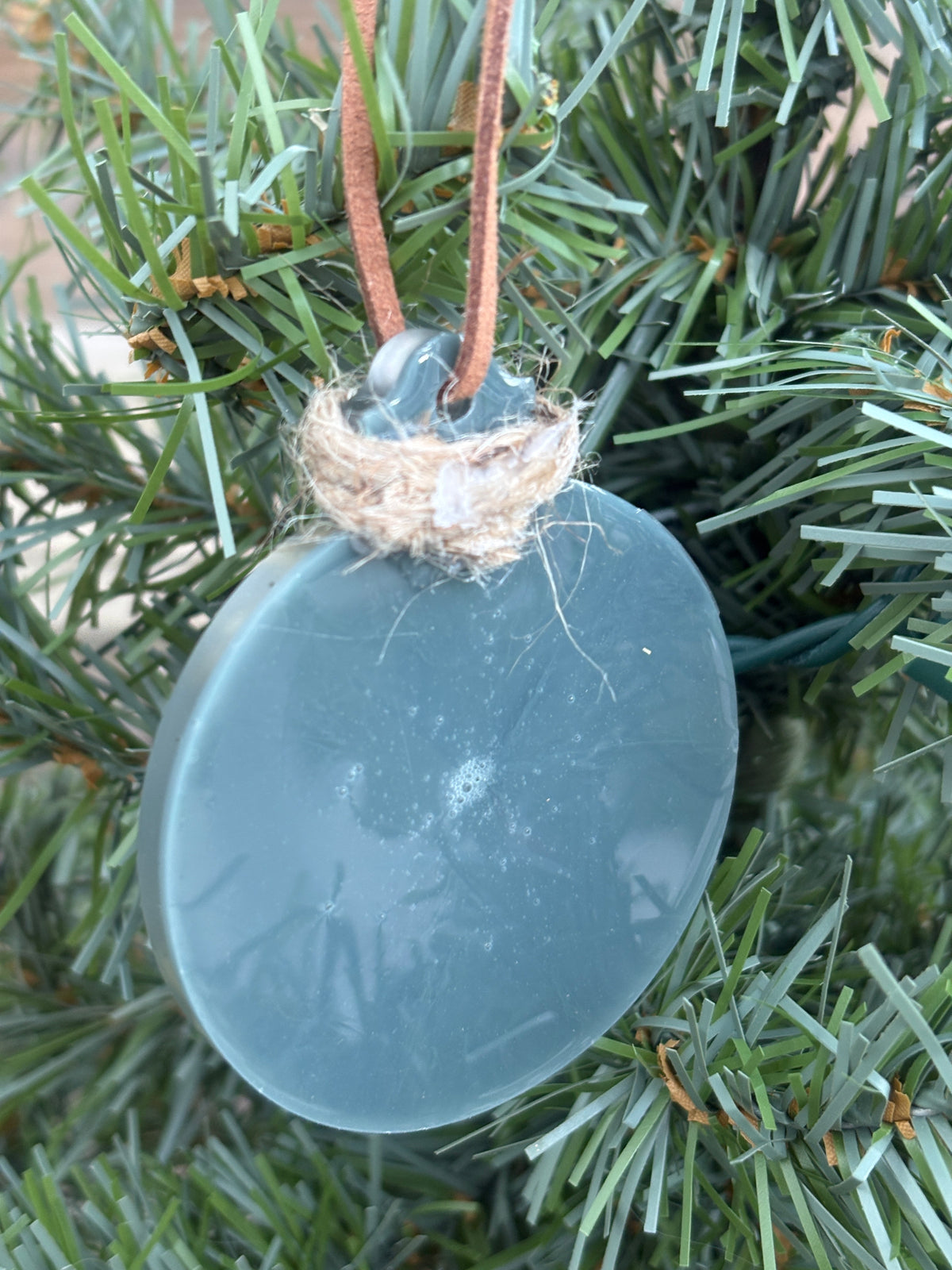 Back of the daisy grey resin ornament showing the smooth reverse side