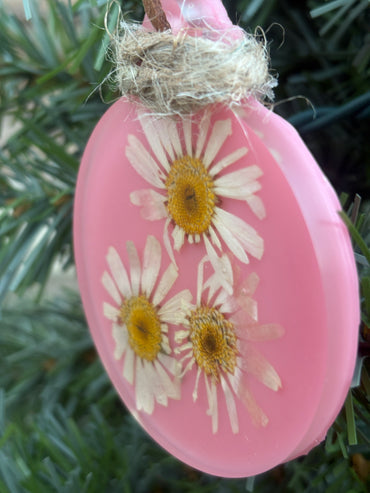 Close-up of pressed daisy ornament in pink resin
