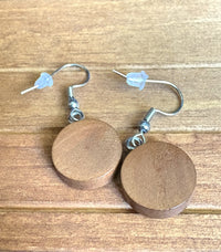Plain round walnut wood dangle earrings showing natural wood grain finish, silver hook hardware