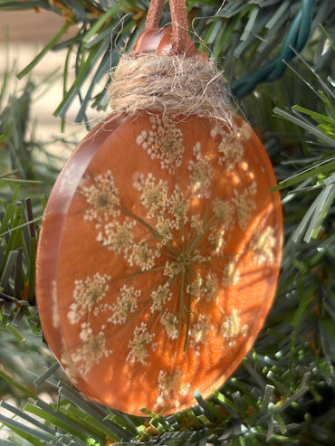 Close-up of Queen Anne's Lace pressed flower ornament in copper resin