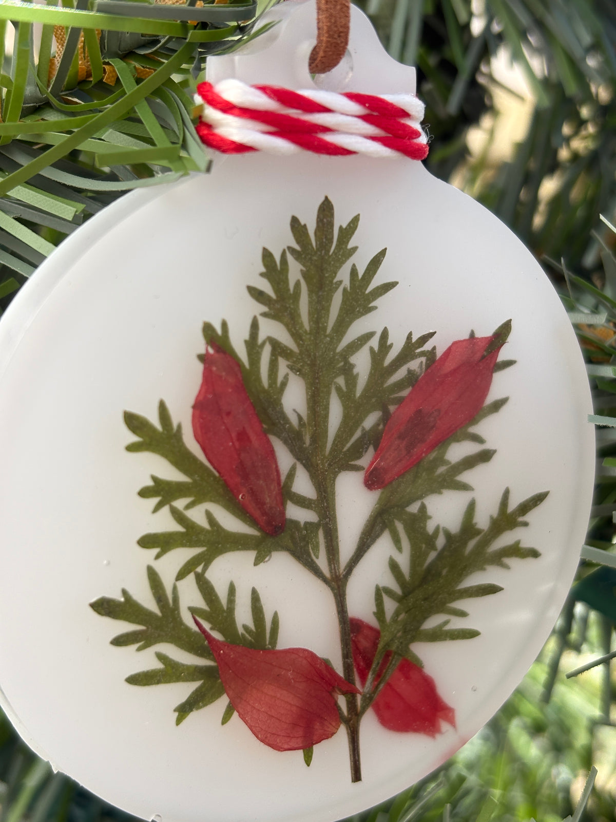 Close-up of Salvia and Artemisia pressed flower ornament in white resin