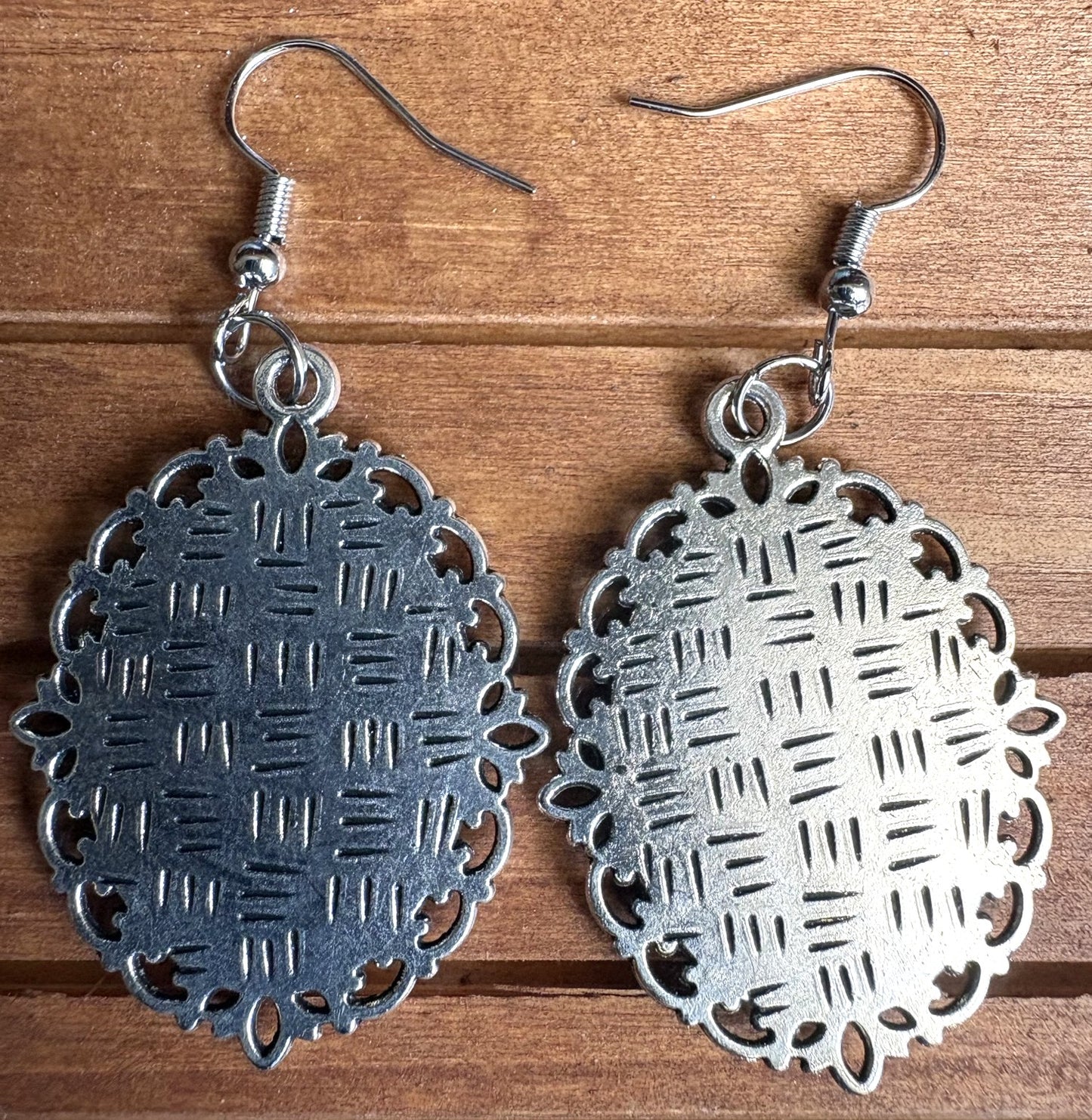 Back view of viola Victorian earrings showing ornate silver filigree metal setting detail